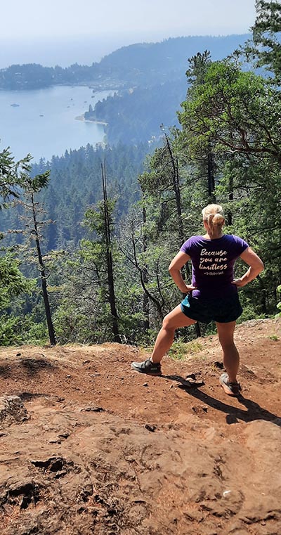 Anke standing on a mountain trail looking over the trees.