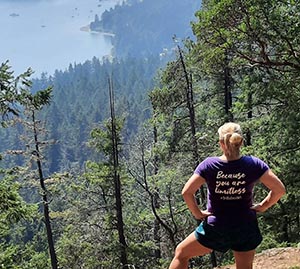 Anke standing on a mountain trail looking over the trees.